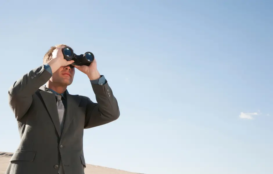 Guy looking through binoculars watching a crime happen.